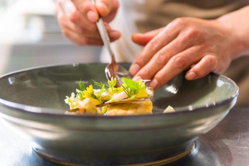 a person eating a dish with a fork and knife at Hotel Mariënhage in Eindhoven