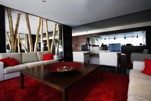 a living room filled with furniture and a red couch at BessaHotel Boavista in Porto