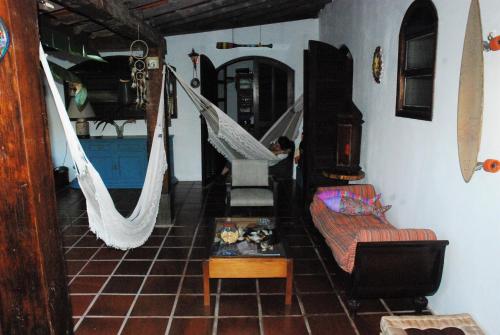 a living room with a couch and hammocks in it at Villa Adria in Ilhabela