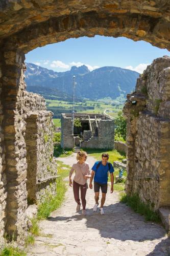 a man and woman walking through an archway at Landhotel Gockelwirt in Eisenberg