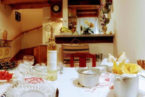 a kitchen table with a bottle of wine and a table cloth at Casa da Mininha in Ponte da Barca