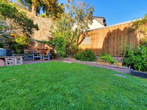 a backyard with a table and a bench and a fence at Gästehaus Klostergasse in Lorch am Rhein
