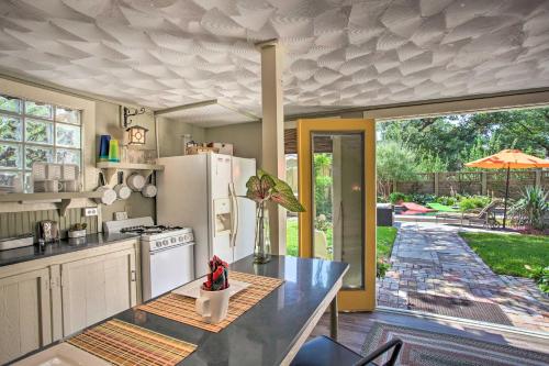 a kitchen with a white refrigerator and a table at 4 Mi to Dtwn! Fort Worth Cottage with Shared Pool in Fort Worth