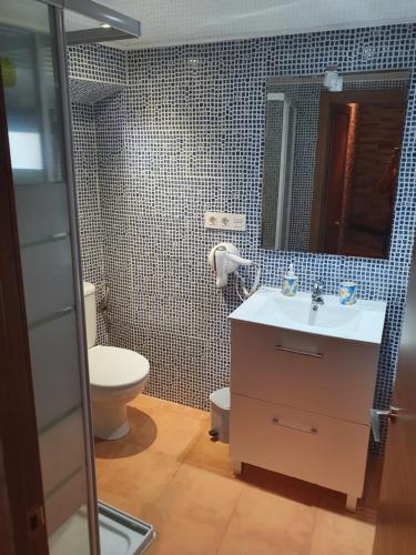uma casa de banho com um lavatório, um WC e um espelho. em Casa Rural Ramos em Linares de la Sierra