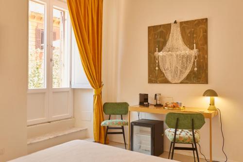 Cette chambre dispose d'un bureau, de deux chaises et d'une fenêtre. dans l'établissement Ripagrande a Trastevere, à Rome