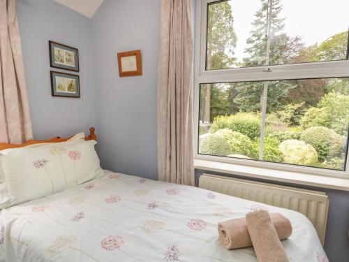 a bedroom with a bed and a window at Anvil Cottage in Near Sawrey