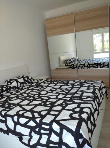 a bedroom with a black and white comforter on a bed at Apartamento boltaña in Boltaña