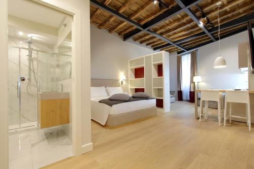 a bedroom with a bed and a shower and a table at Monti Panisperna suites in Rome