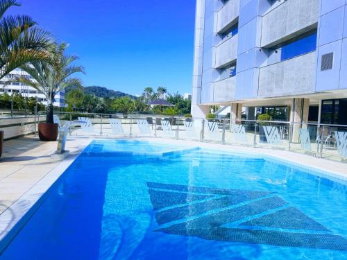 a large blue swimming pool next to a building at Alven Hotel by Slaviero Hotéis in Joinville