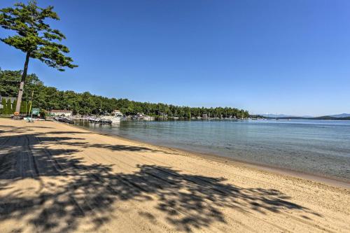 a shadow of a tree on a beach at Lake Getaway Walk Across Street to Private Beach! in Gilford