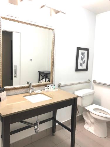 a bathroom with a sink and a toilet and a mirror at Country Inn & Suites by Radisson, San Jose International Airport, CA in San Jose