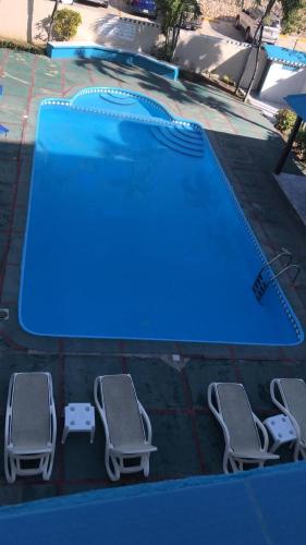 a swimming pool with two lounge chairs next to it at La Gaviota B3 in Juan Dolio