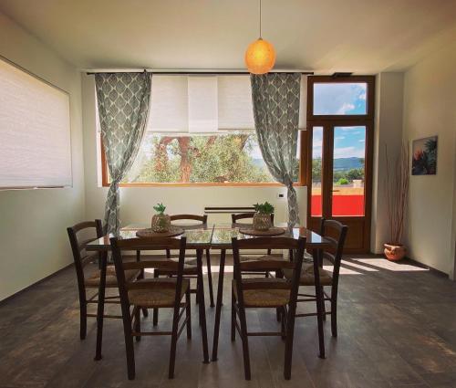 a dining room with a table and chairs and a window at Tenuta Fascianello in Fasano