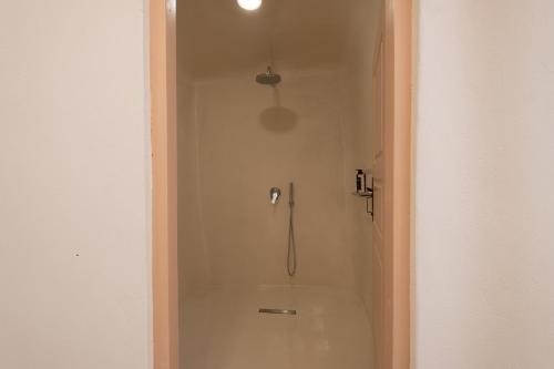 a shower stall in a white bathroom with a shower at Abelis Canava Luxury Suites in Vóthon