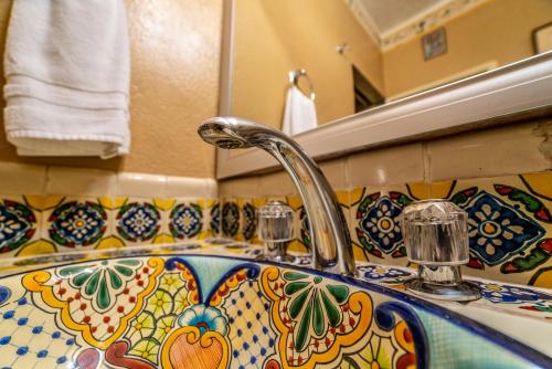 a bathroom sink with a colorful tile on it at Villa Mirasol in San Miguel de Allende