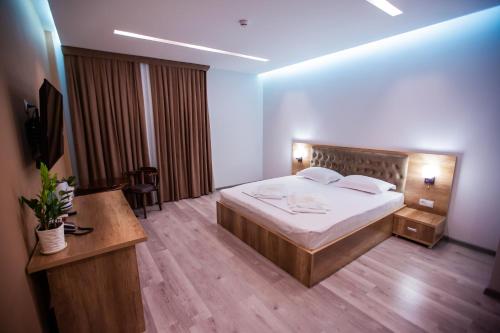 a bedroom with a bed and a desk and a television at Hotel Ak Saray in Tashkent