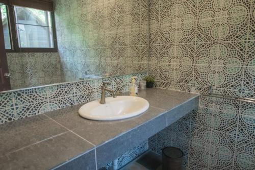 a bathroom with a sink and a mirror at De Serenity - Exclusive Jungle Retreat in Seremban