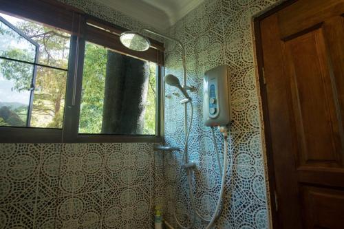a shower in a bathroom with a window at De Serenity - Exclusive Jungle Retreat in Seremban