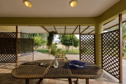 einen Tisch auf einer abgeschirmten Veranda mit einem Tisch und Stühlen in der Unterkunft Ktima Anastasia in Nafplio