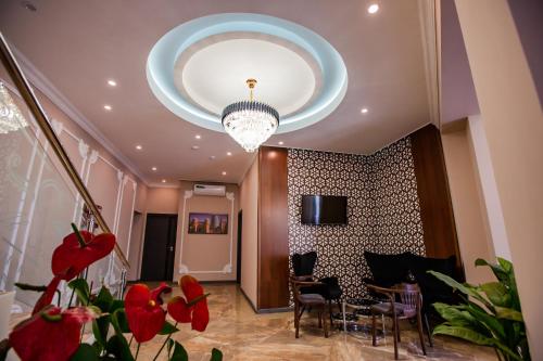 a living room with a chandelier and red flowers at Hotel Ak Saray in Tashkent