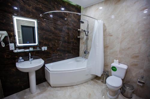 a bathroom with a sink and a toilet and a shower at Hotel Ak Saray in Tashkent