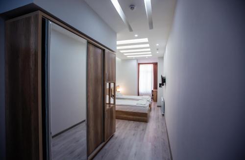 a room with a bedroom with a bed and a mirror at Hotel Ak Saray in Tashkent