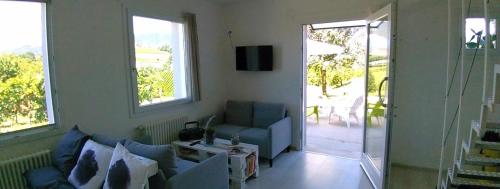 uma sala de estar com um sofá azul e janelas em La Casetta em Vittorio Veneto