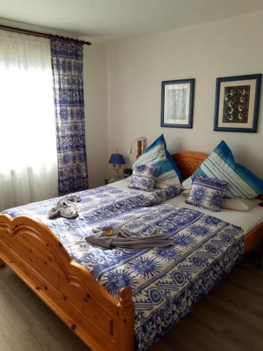 um quarto com uma cama grande com lençóis azuis e brancos em Ferienwohnung Hummer im Haus Daheim em Helgoland