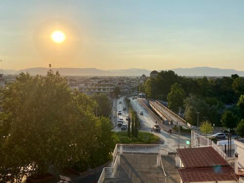 a view of a city with the sun setting at Ξενοδοχείο Acropol in Larisa