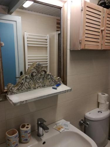 a bathroom with a sink and a mirror and a toilet at La Perla in piazza Duomo a Pietrasanta in Pietrasanta