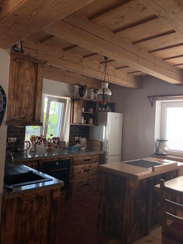 a kitchen with wooden cabinets and a refrigerator at Vojnův Městec Dům s vůní dřeva in Žďár nad Sázavou