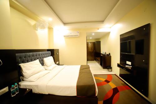 a hotel room with a bed and a flat screen tv at Hotel Jaipur Legacy in Jaipur