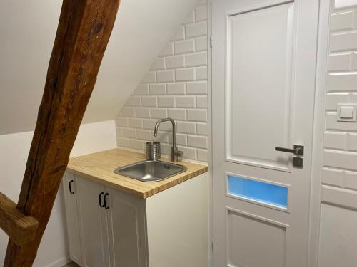 a small kitchen with a sink next to a door at Przystań w Pucku in Puck