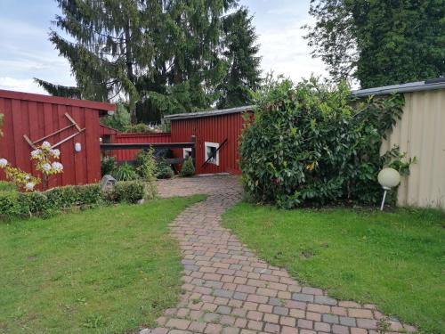 a brick path in front of a red building at Ferienwohnung Am Atelier in Rathenow