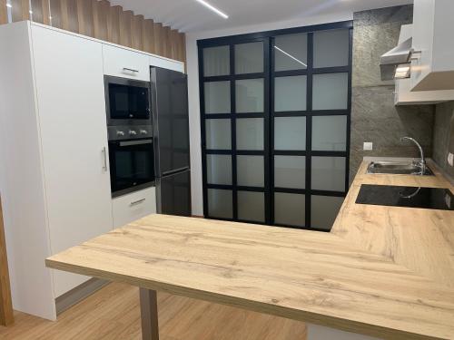 a kitchen with a wooden counter top in a room at Oktheway Pedro Saco Street in Sarria