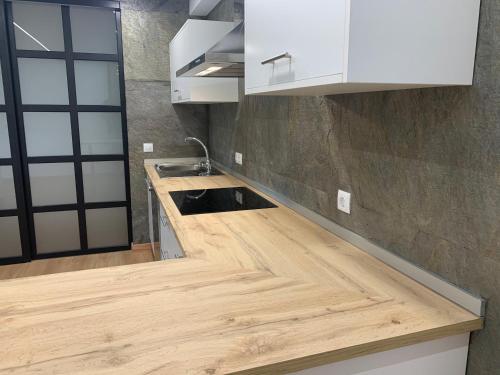 a kitchen with white cabinets and a wooden counter top at Oktheway Pedro Saco Street in Sarria