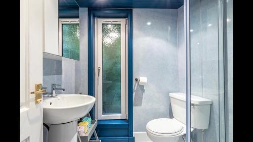 a bathroom with a white toilet and a sink at Lamont Cottage in Inverness