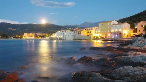 une ville sur la rive d'une masse d'eau la nuit dans l'établissement Studio tout équipé de 27m2, à 100m de la mer, et 500m des commerces, à Algajola