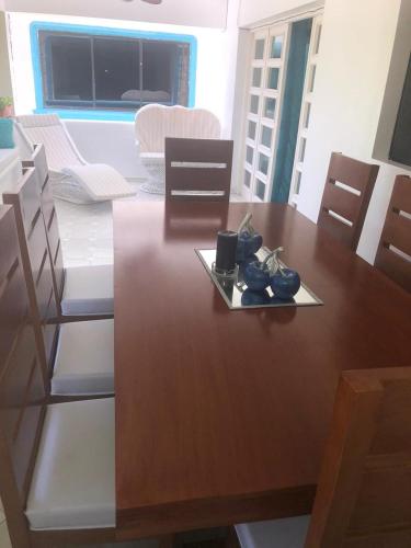 a wooden dining room table with a plate on it at La Gaviota A3 in Juan Dolio