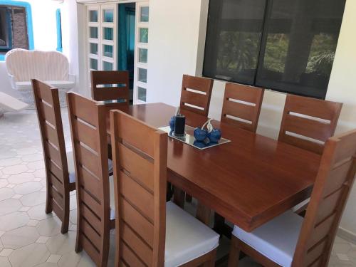 a dining room table with chairs and a wooden table at La Gaviota A3 in Juan Dolio