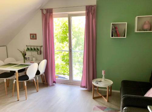 ein Wohnzimmer mit einem Tisch und einem Fenster in der Unterkunft Apartment Kirschti in Salzwedel