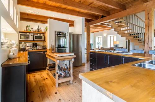 a large kitchen with wooden floors and a staircase at Cottage Jacques Cartier in Stoneham