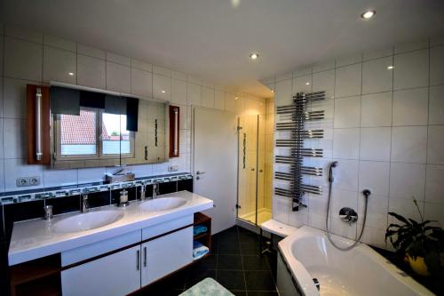 ein Badezimmer mit 2 Waschbecken und einer Badewanne in der Unterkunft Ferienwohnung INGRID in Markt Erlbach
