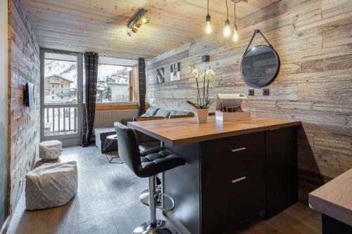 een kantoor met een bureau in een kamer met houten wanden bij Appartement de charme hyper centre à Val d'Isère in Val dʼIsère
