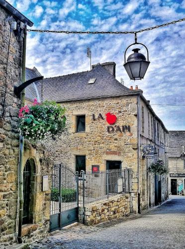 Um velho edifício de pedra com um sinal. em Le Clos St Yves em Saint-Pol-de-Léon