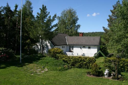 une maison blanche avec un toit noir dans l'établissement Poeme A SANDEFJORD, à Kodal