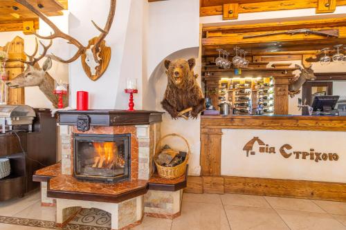 a fireplace with a bear hanging on the wall at Hotel Pid Strihoju in Bukovel