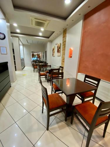 a dining room with wooden tables and chairs at Ξενοδοχείο Acropol in Larisa