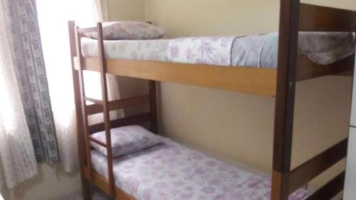 Łóżko lub łóżka piętrowe w pokoju w obiekcie Hostel Jandira