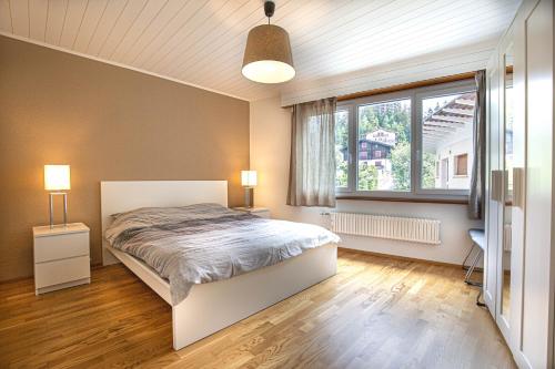 ein Schlafzimmer mit einem Bett und einem großen Fenster in der Unterkunft Le Clavan in Crans-Montana